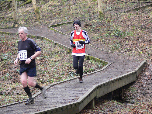 Trevor Wilkinson traversing the last bit of the obstacle course - trying not to slip off the logs - as he approaches the finish